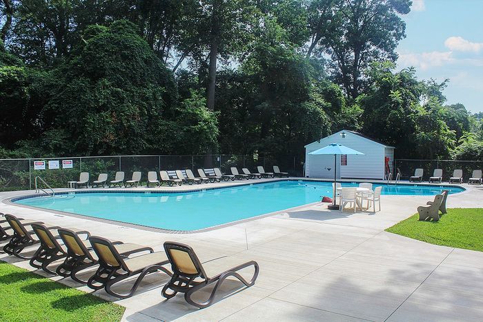 Inviting outdoor swimming pool with comfortable lounge chairs and lush green surroundings, perfect for relaxation and recreation.