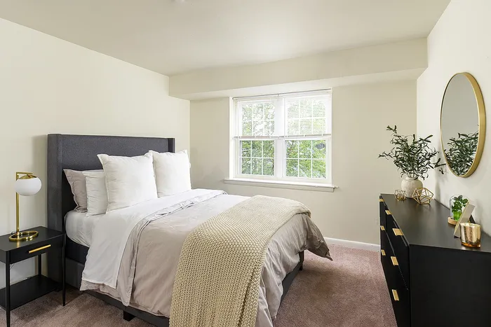 Bright and inviting bedroom with a plush bed, large window, and chic decor elements for a soothing ambiance.
