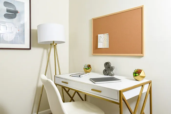 Chic home office nook with elegant white desk, stylish gold accents, and modern decor for an inspiring workspace.
