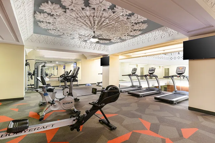 Elegant fitness center featuring state-of-the-art gym equipment, modern design, and a stunning decorative ceiling.