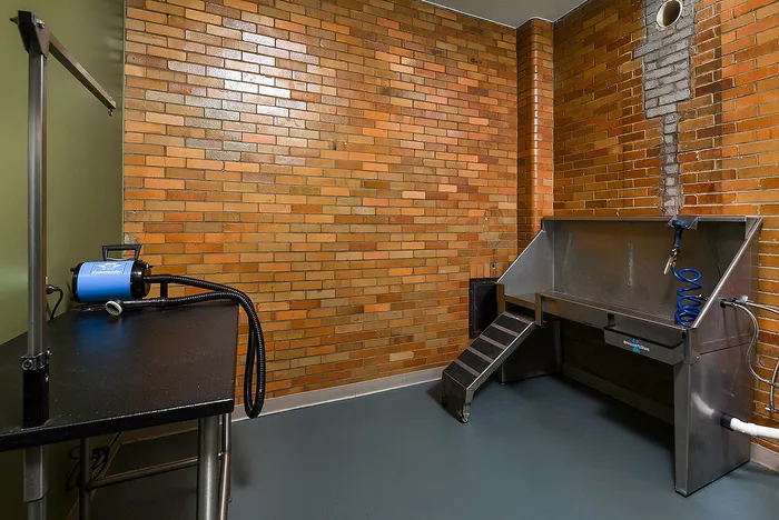 Unique industrial-style room with exposed brick walls, featuring a versatile workspace with metal fixtures and practical equipment.