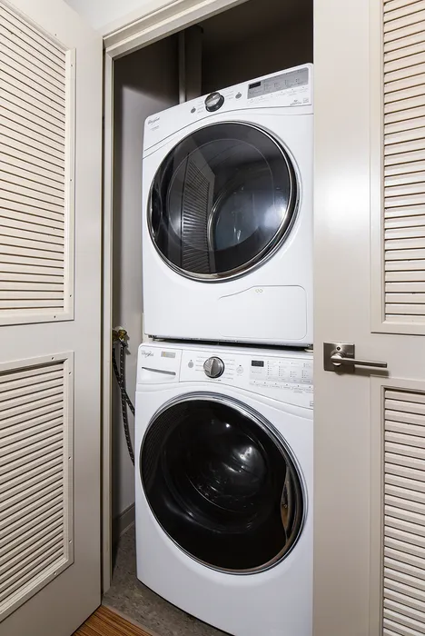 Modern apartment with a sleek, stacked washer and dryer set in a compact laundry nook, optimizing space and convenience.