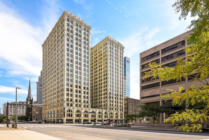 Impressive cityscape featuring a historic high-rise building under a vibrant blue sky, perfect for urban living in the heart of the city.