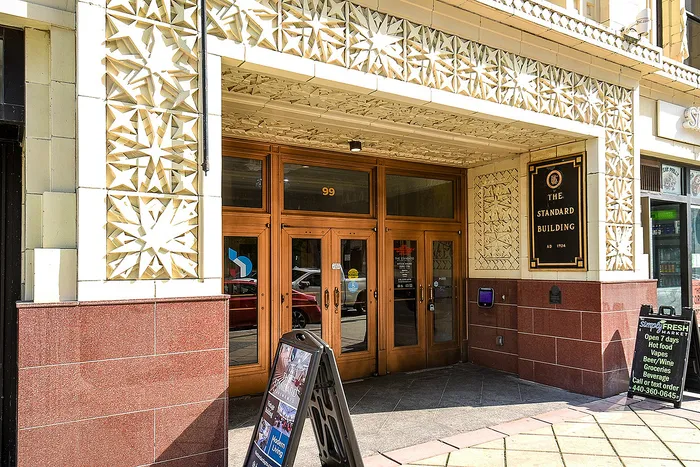 Elegant entrance of The Standard Building with intricate star-patterned facade, emphasizing its historic architectural charm.