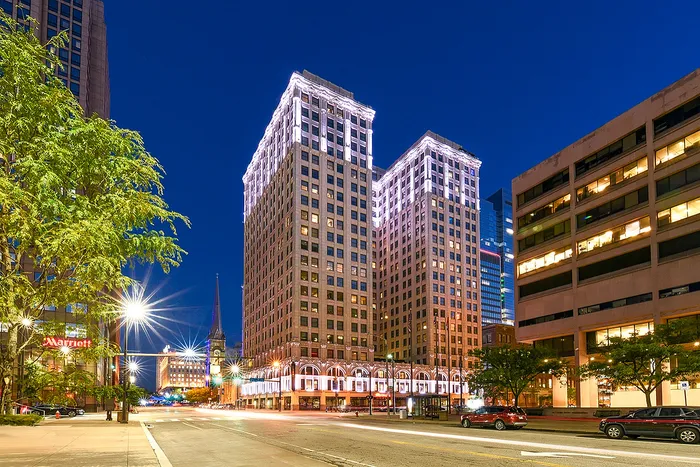Elegant illuminated skyscrapers at dusk, showcasing modern urban living in a vibrant downtown setting.