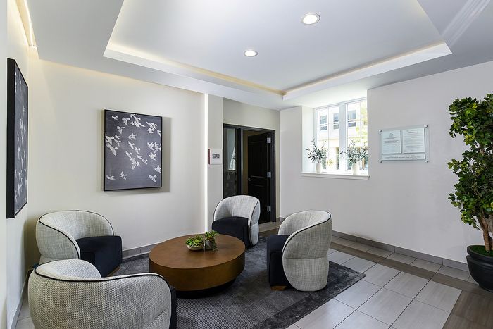 Elegant lobby area with plush chairs, modern artwork, and natural light creating a welcoming ambiance.