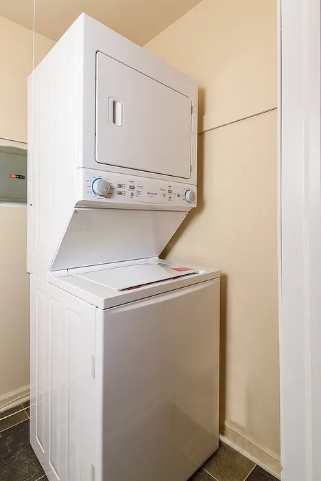 Efficient in-unit laundry with a modern stacked washer and dryer set, perfect for convenient living.