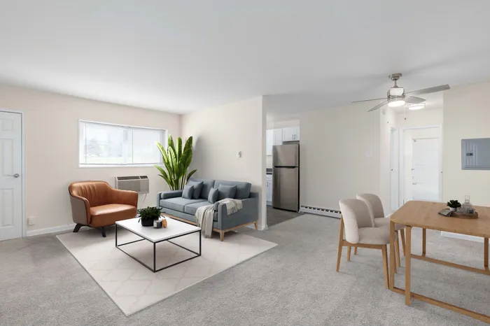 Inviting living room with modern furniture, featuring a comfy sofa, chic armchair, elegant coffee table, and bright dining area perfect for entertaining.