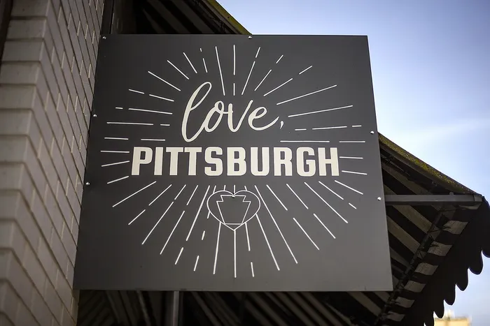Charming outdoor sign with 'Love, Pittsburgh' invoking a warm welcome and local pride.