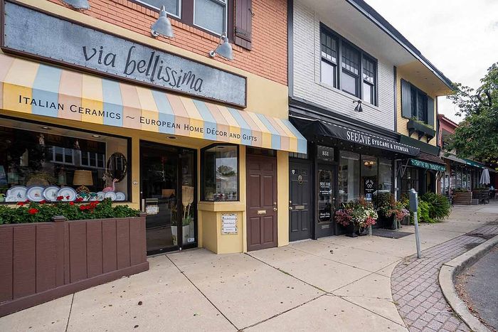 Charming street view showcasing European-themed home decor and eyewear shops with inviting storefronts.