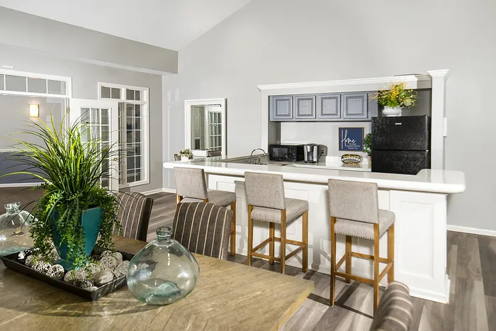 Modern open-concept kitchen and dining area with sleek countertops, elegant bar stools, and abundant natural light.