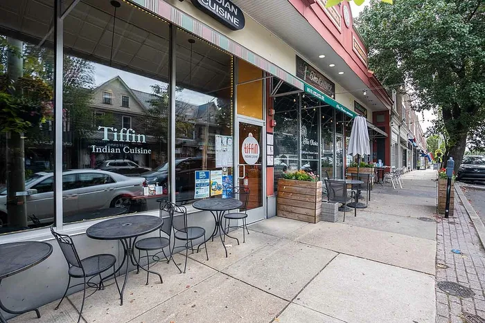 Charming street view of cozy outdoor seating at Tiffin Indian Cuisine, offering a taste of authentic flavors in a vibrant neighborhood setting.
