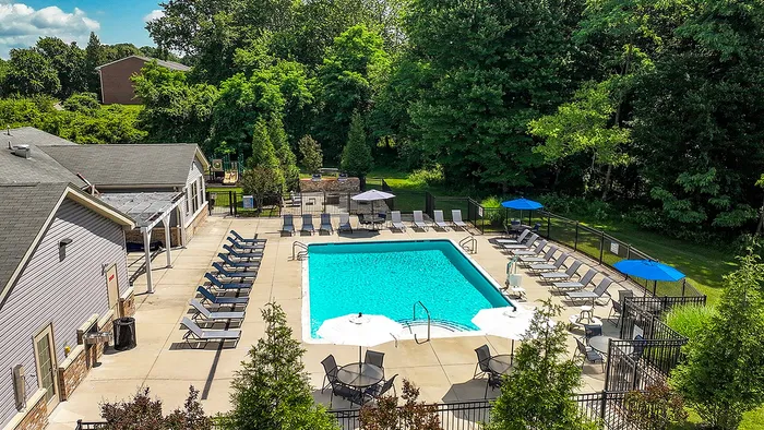Inviting outdoor pool area surrounded by lush greenery and sun loungers, offering a perfect retreat for relaxation and leisure.