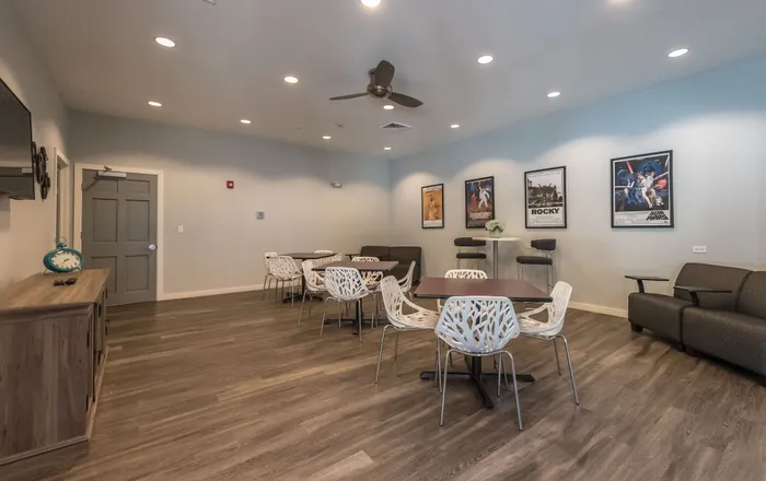 Inviting recreation room with modern decor, stylish seating, and iconic movie posters on the wall, perfect for relaxation and entertainment.
