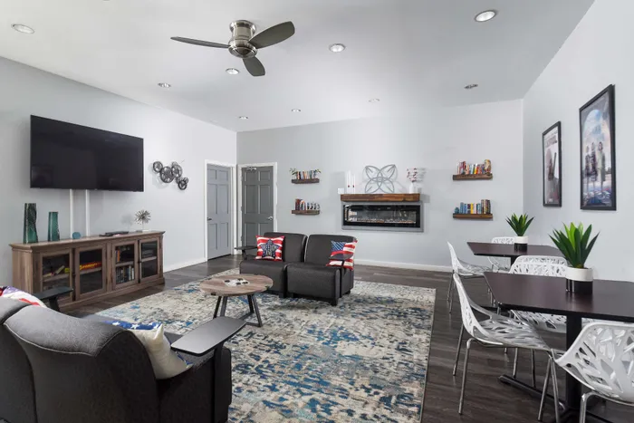 Modern living room with stylish decor, a large TV, and cozy seating area, ideal for relaxation and entertainment.