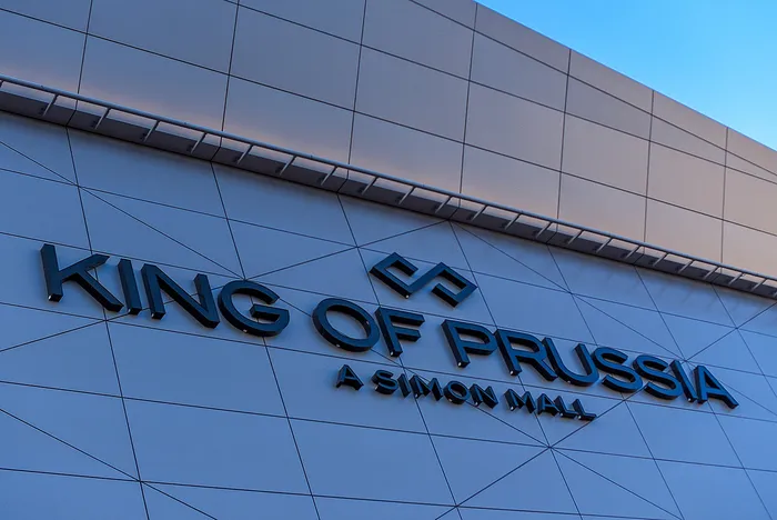 Modern architectural facade of King of Prussia mall, featuring sleek geometric design and bold lettering.