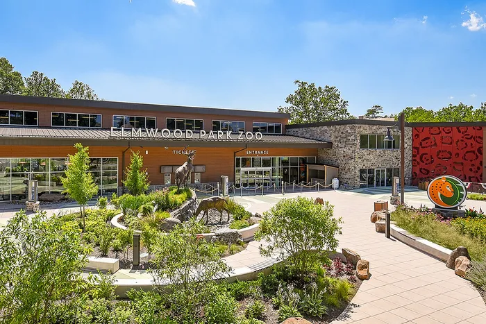 Inviting entrance to Elmwood Park Zoo with vibrant landscaping, sleek architecture, and stunning animal sculptures.