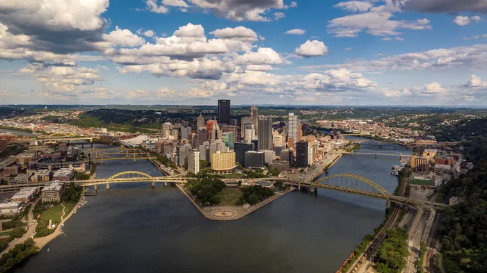 Breathtaking aerial view of a vibrant cityscape with iconic yellow bridges spanning across the scenic rivers.