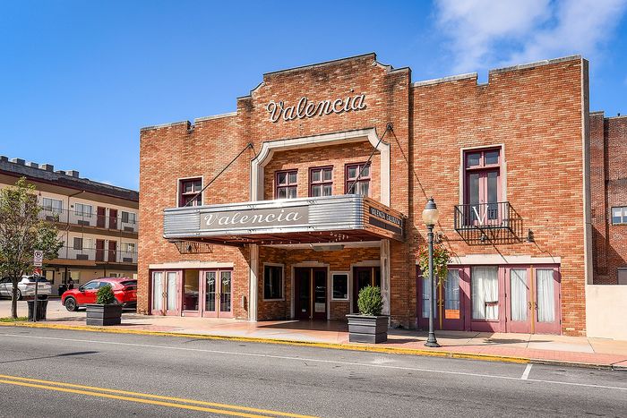 Charming historic Valencia building with classic brick facade and vintage marquee, capturing timeless architectural elegance.