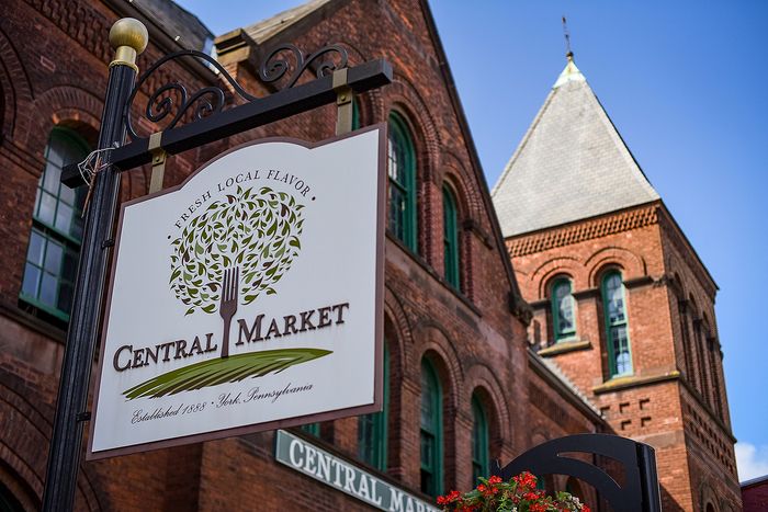 Charming Central Market sign against a historic brick building, showcasing fresh local flavor in York, Pennsylvania.