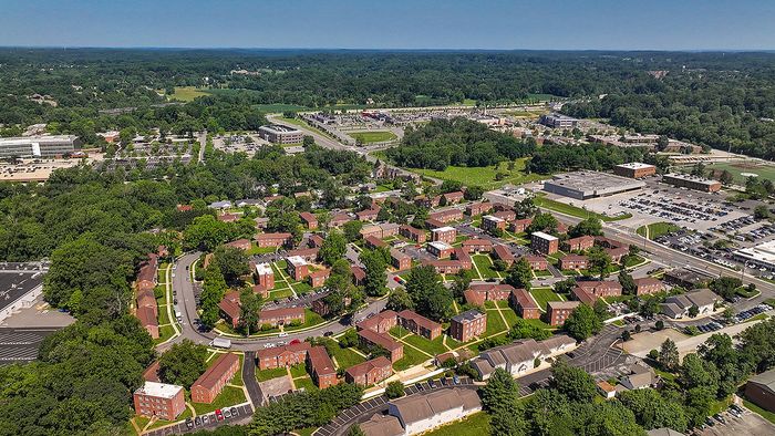 Expansive aerial view of a vibrant residential neighborhood with lush greenery, modern facilities, and convenient access to urban amenities.