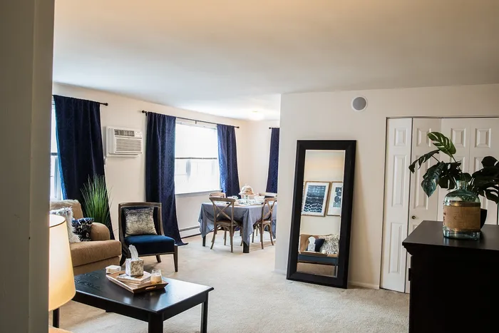 Inviting living and dining area with elegant dark blue curtains, plush seating, and stylish decor, perfect for modern living.