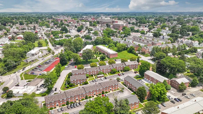 Charming aerial view of a vibrant apartment complex nestled in lush greenery, offering a tranquil suburban lifestyle with easy access to city amenities.