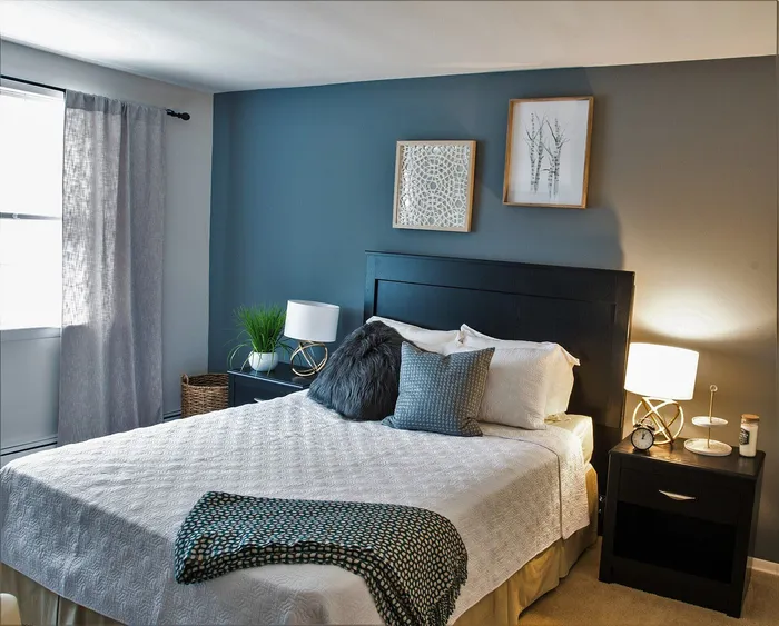 Cozy bedroom with elegant decor, featuring a plush bed with stylish pillows, modern nightstands with chic lamps, and tasteful wall art creating a serene ambience.