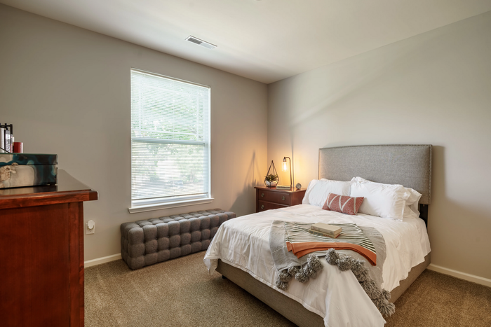 Inviting and stylish bedroom with a plush bed, elegant bedside table, and soft natural lighting, perfect for relaxation.