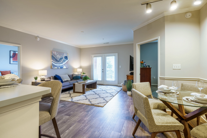 Elegant open-plan living and dining area with modern decor, cozy furniture, and inviting natural light from the patio doors.