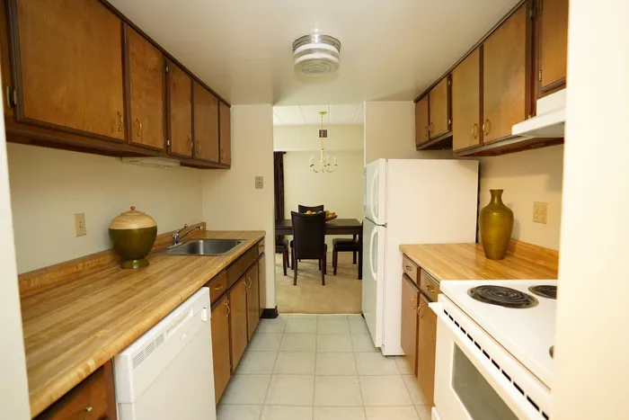 Inviting kitchen with warm wood cabinetry, spacious countertops, and a view into a cozy dining area.