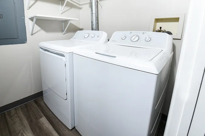 Modern laundry room featuring sleek white washer and dryer units against a pristine backdrop, offering convenience and style.