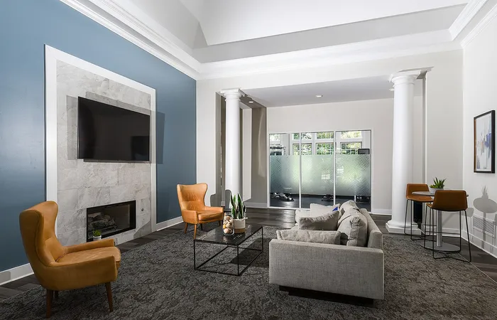 Elegant living room with high ceilings, marble fireplace, and plush seating. Natural light brightens the modern open-concept design.