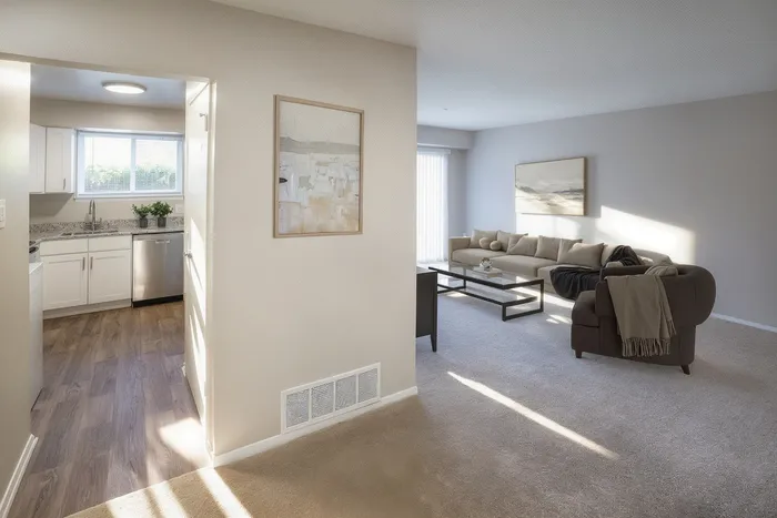 Bright and inviting open-concept apartment featuring a cozy living room with plush seating and a contemporary kitchen with modern appliances.