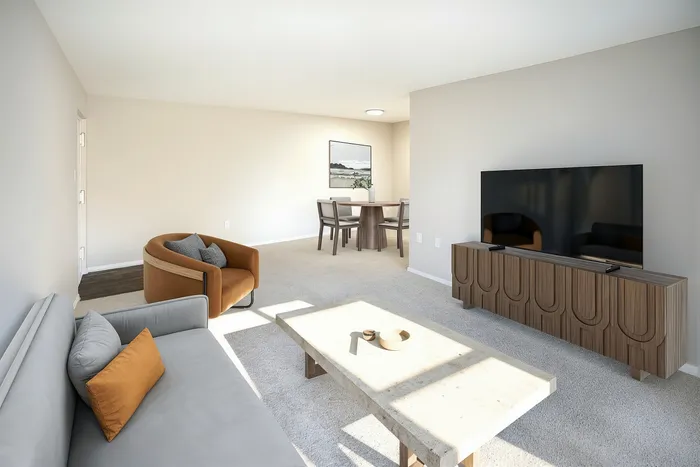 Bright and airy living room featuring contemporary furniture, a sleek TV setup, and an inviting dining area perfect for modern living.