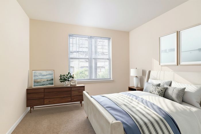 Bright and inviting bedroom with elegant decor, featuring a plush bed, modern wooden dresser, and large window illuminating the space.
