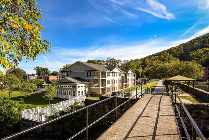Charming apartment complex nestled in lush greenery with scenic park views and a sunny outdoor space.
