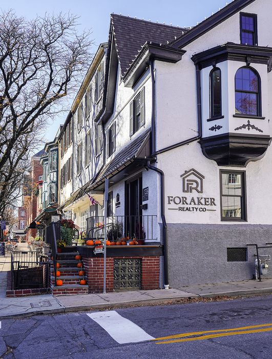 Charming urban townhouse with festive pumpkin decor, showcasing elegant architecture and a welcoming terrace, perfect for cozy city living.
