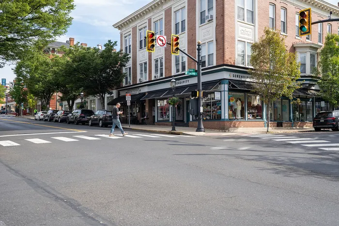 Charming corner building with stylish storefronts, nestled in a vibrant and leafy neighborhood street.