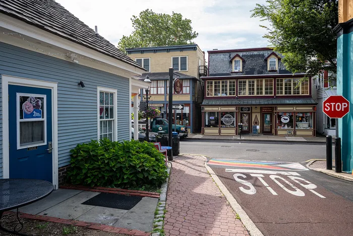 Charming small-town street scene with colorful buildings, a cozy cafe, and vibrant flowers.