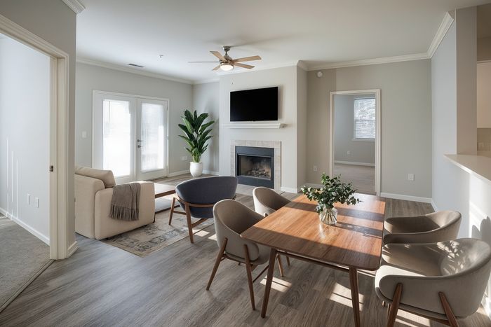 Bright and inviting living area with modern furnishings, elegant fireplace, and natural light streaming through French doors.