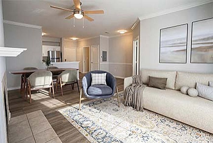 Elegant open-concept living and dining area with contemporary furniture, large windows, and warm lighting.