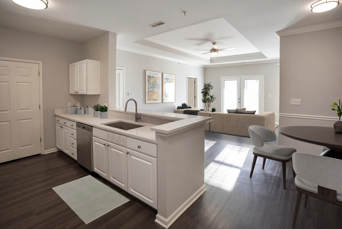 Bright, modern open-plan kitchen and living area featuring sleek white cabinetry, chic decor, and ample natural light.