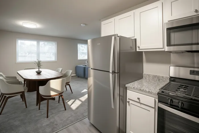 Bright and modern kitchen and dining area featuring stainless steel appliances, granite countertops, and elegant seating for six.