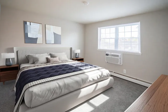 Bright and inviting bedroom with a plush king-sized bed, modern decor, and ample natural light through large windows.