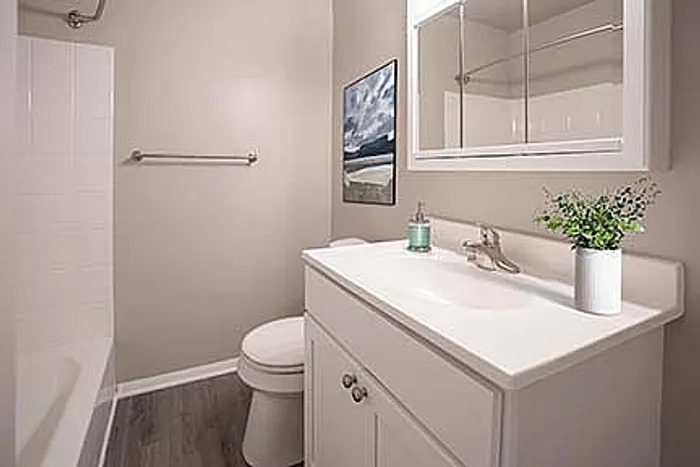Contemporary bathroom with sleek white vanity, modern fixtures, and elegant wall decor.