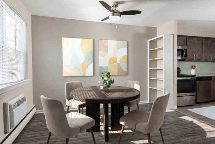 Chic dining area featuring a round table with elegant chairs, modern artwork, and open access to a contemporary kitchen.