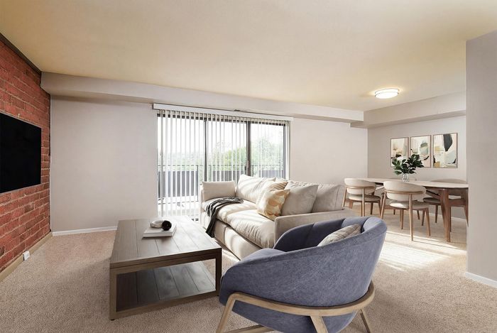 Bright and inviting living room with cozy seating, modern decor, and large windows opening to a scenic balcony view.