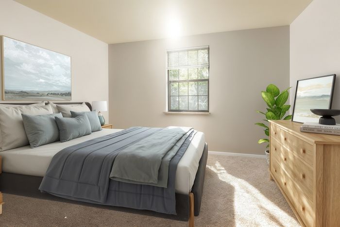 Bright and inviting bedroom with a cozy bed, elegant decor, and sunlight streaming through a large window.