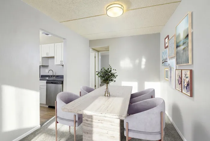 Chic dining room with a modern table, plush chairs, and elegant artwork, seamlessly connected to a stylish kitchen.